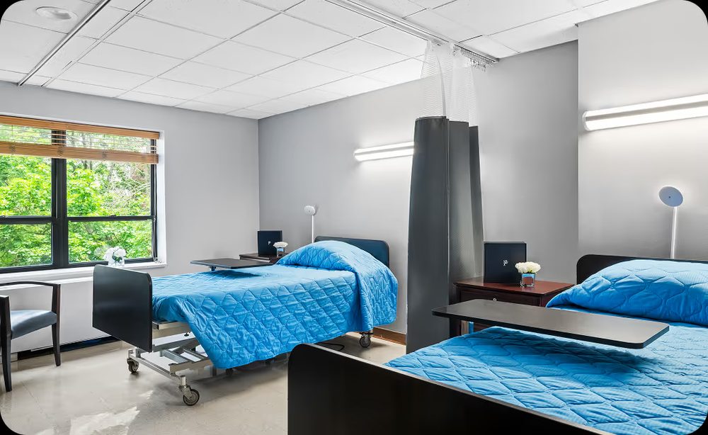 A bright resident room with twin beds and a window